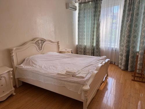 a bedroom with a white bed and a window at Аркадия, Генуэзская in Odesa