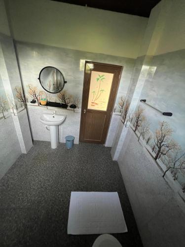 a bathroom with a toilet and a sink and a door at The Red Loft Mihinthale in Anuradhapura