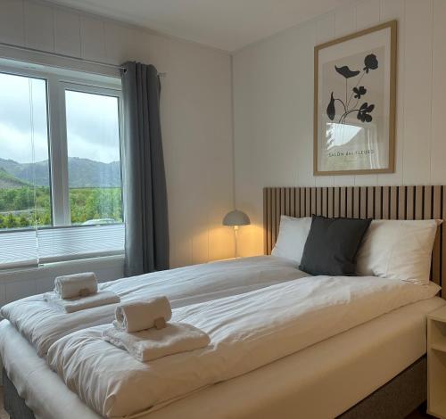 a bedroom with a large bed with two towels on it at Selvbetjent leilighetshotell på Ålgård in Ålgård