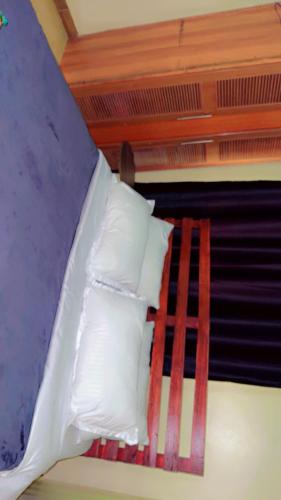 a bunk bed with white pillows and a ladder at Malaika Villas in Kampala