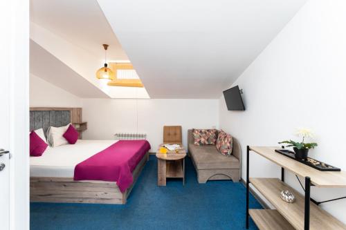 ein Hotelzimmer mit einem Bett und einer Couch in der Unterkunft Alex Hotel in Yerevan