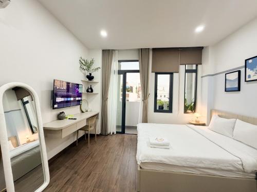 a bedroom with a bed and a desk with a mirror at SP house in Ho Chi Minh City