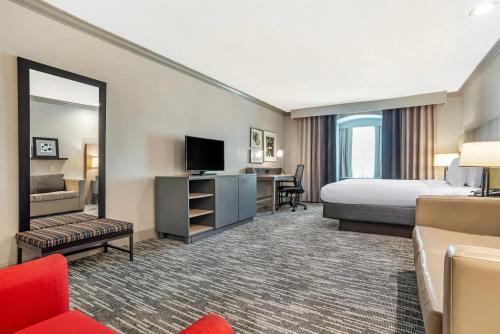 a hotel room with a bed and a television at Country Inn & Suites by Radisson, Metairie New Orleans , LA in Metairie