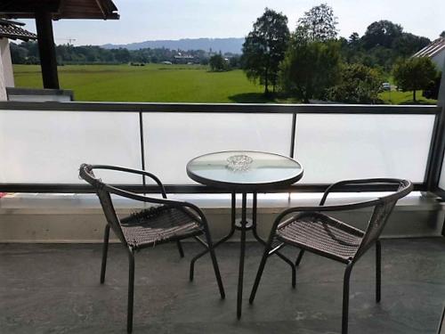a glass table and two chairs on a balcony at Privatzimmer Reiner Baumeister in Lindau