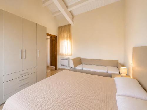 a white bedroom with a bed and a couch at Oasi Frontemare Appartamenti in Pineto