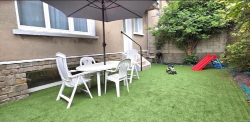 a patio with a table and chairs and an umbrella at Escapade Bord de Mer - Terrasse & Parking privé, Plage à 300 m in Le Portel