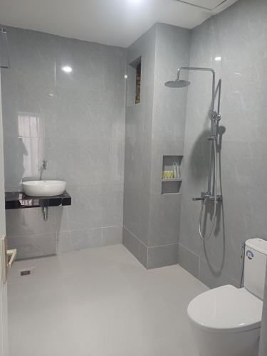a bathroom with a shower and a toilet and a sink at Lekjon Cottage in Tuktuk Siadong