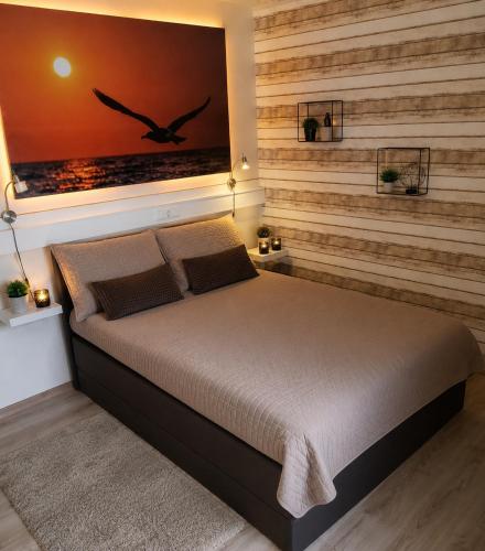 a bedroom with a bed with a wall with a bird picture at Ferienwohnung Möwe in Schönberg