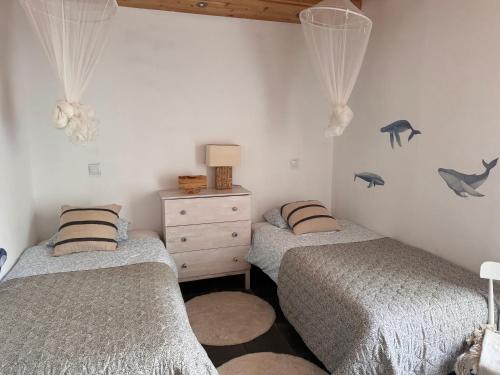 a bedroom with two twin beds and a dresser at Waka Sun Set PICO AZORES in São Roque do Pico