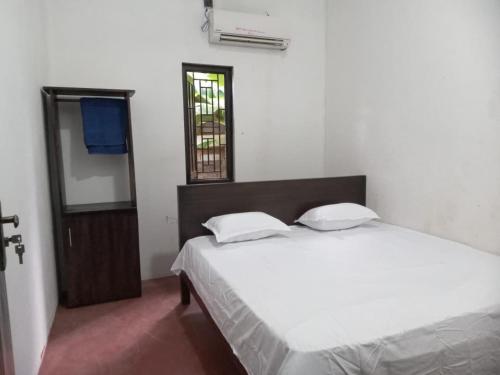 a bedroom with a large white bed and a mirror at Breezy Villa - Arugambay in Arugam Bay