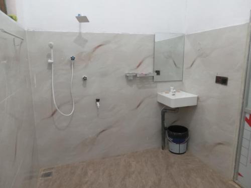 a white bathroom with a shower and a sink at Breezy Villa - Arugambay in Arugam Bay