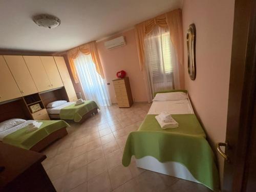 a room with two beds with green sheets at Fiumicino River in Fiumicino