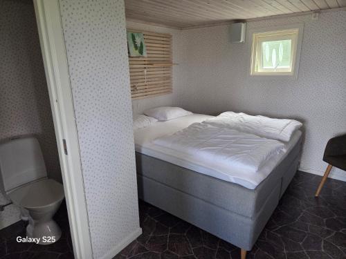 a bed in a small room with a window at Askeviks Camping & Stugor in Sjötorp