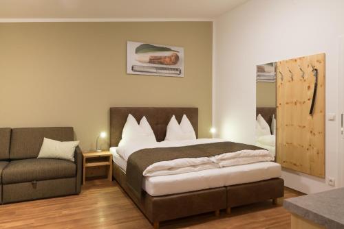 1 dormitorio con cama y sofá en Wirtshausbrennerei Krenn, en Yspertal