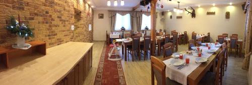 a restaurant with tables and chairs in a room at Willa Hamernik AGROTURYSTYKA in Tylicz