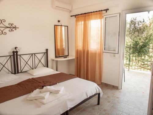 a bedroom with a bed and a large window at Iron House in Agios Georgios