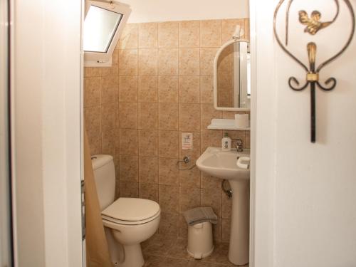 a small bathroom with a toilet and a sink at Iron House in Agios Georgios