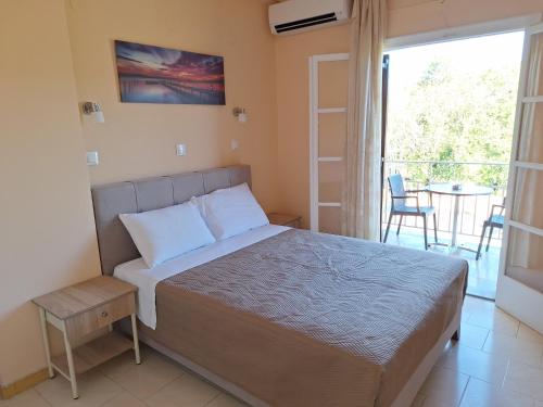 a bedroom with a bed and a balcony with a table at River Studios & Apartments in Mesongi