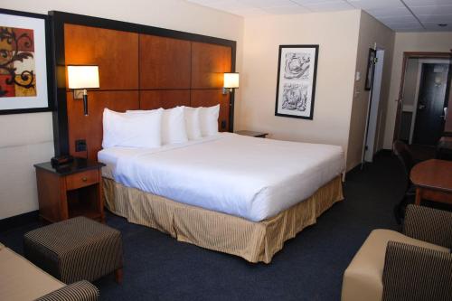 a hotel room with a large bed and chairs at Rodeway Inn in Grand Falls