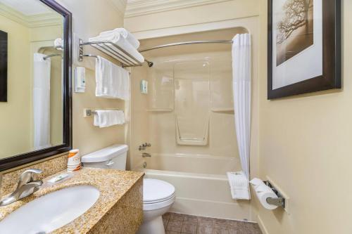 a bathroom with a sink and a toilet and a tub at Quality Inn & Suites High Level in High Level