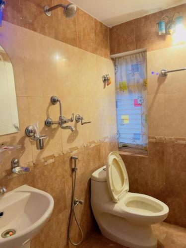 a bathroom with a white toilet and a sink at Hotel Mirana Pvt Ltd in Kathmandu