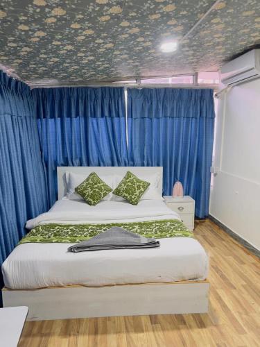 a bedroom with a large bed with blue curtains at Hotel Mirana Pvt Ltd in Kathmandu