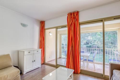 a living room with a couch and a window at Flat With Swimming Pool Near The Beach in Sanary-sur-Mer