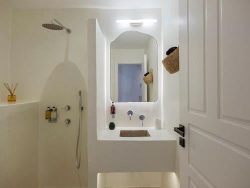 a white bathroom with a sink and a mirror at myMykonos Guest House in Platis Gialos