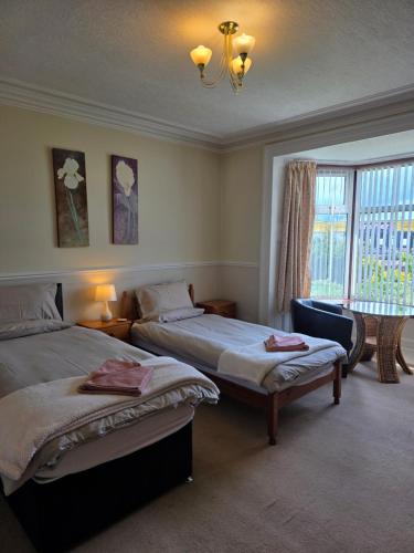 a bedroom with two beds and a window at Beeches Guest House in Dyce