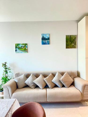 a living room with a brown couch with pillows at SeaBreeze Resort Baku Apartment Studio in Baku