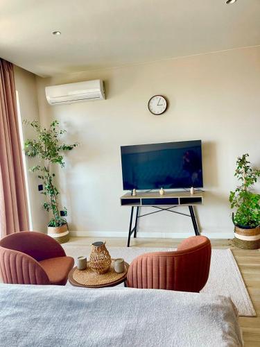 a living room with a tv and two chairs at SeaBreeze Resort Baku Apartment Studio in Baku