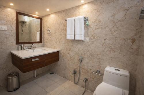 a bathroom with a toilet and a sink and a mirror at 4 Bedroom Luxury Bungalow In Manali With Beautiful Scenic Mountain & Orchard View - #Private Bungalow #Premium Big rooms #Parking #Guest Preferred in Manāli