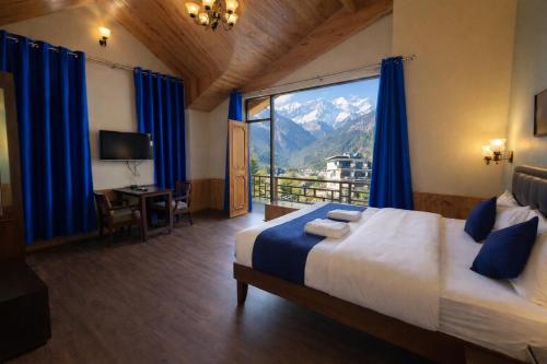 a bedroom with a bed and a view of a mountain at 4 Bedroom Luxury Bungalow In Manali With Beautiful Scenic Mountain & Orchard View - #Private Bungalow #Premium Big rooms #Parking #Guest Preferred in Manāli