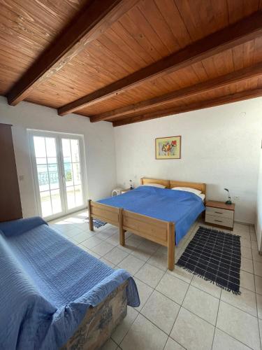 a bedroom with two beds and a wooden ceiling at Apartman Grospic in Cesarica