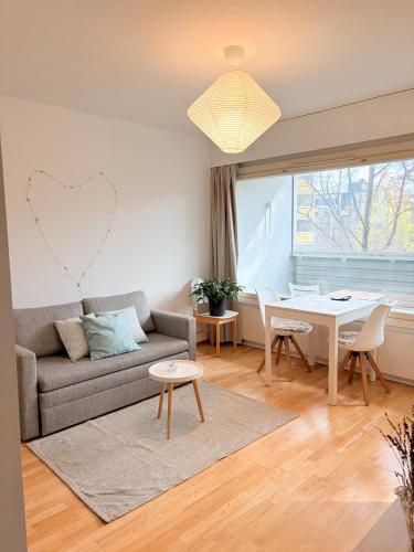 a living room with a couch and a table at Peaceful studio in Vantaa in Vantaa