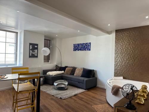 a living room with a couch and a table at Les Nuits Douces in Bitche