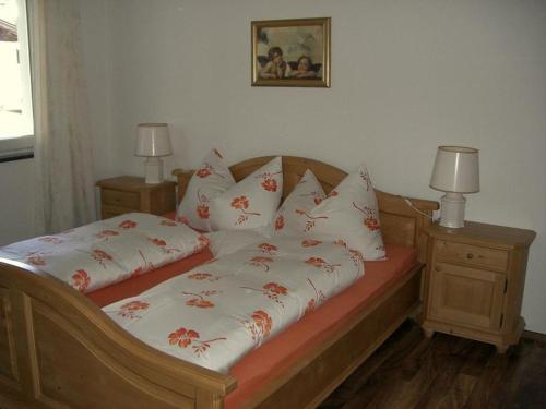 a bed with red and white pillows on it at Appartement Schatz in Uderns