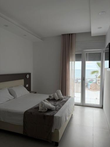a bedroom with a bed and a view of the beach at Albergo Diomedee Rooms on the Beach in Rodi Garganico