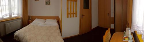 a small bedroom with a bed and a table at Willa Hamernik AGROTURYSTYKA in Tylicz