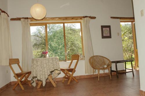 a dining room with a table and chairs and a window at Andean Spirit Lodge in Mollepata