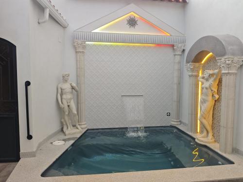 a pool of water in a room with two statues at AniCa IV De Cine in Tomelloso
