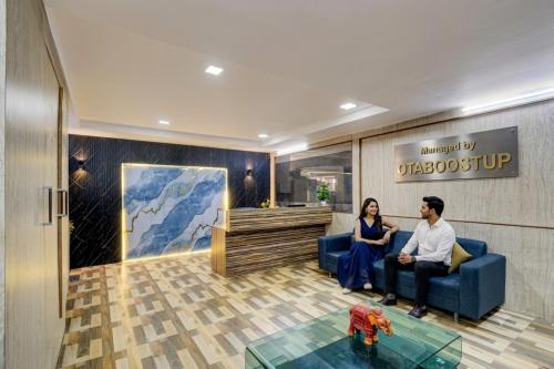 a man and woman sitting on a couch in a lobby at Hotel Velvet Stay Near DLF Cyber City in Hyderabad