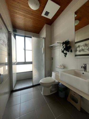 a bathroom with a toilet and a sink and a shower at Come Home Travel in Tainan