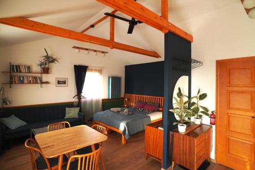 a bedroom with a bed and a living room at Surányi kék házak in Pócsmegyer