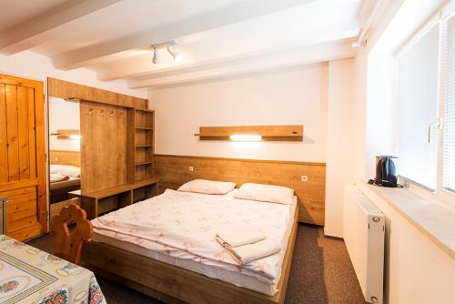 a small room with a bed in a room at Penzión Šuštiak in Terchová