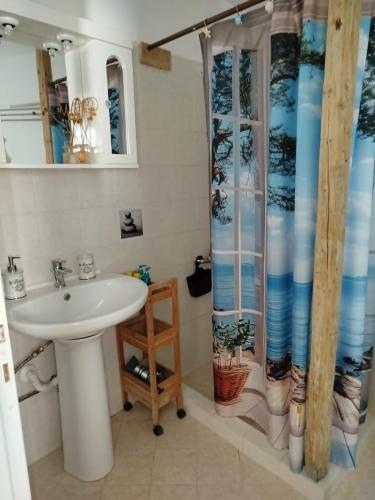 a bathroom with a sink and a shower at B&B Hestia's Hideaway in Kalívia Thorikoú