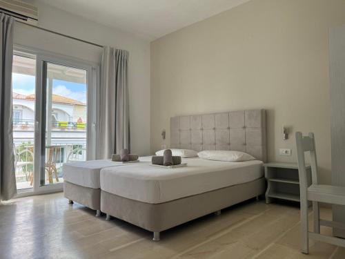 a bedroom with a large bed and a large window at Ammos Apartments in Kavos