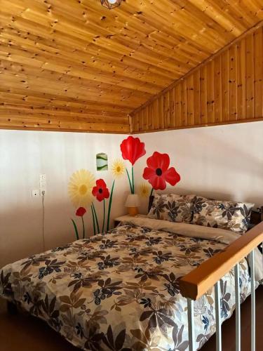 ein Schlafzimmer mit einem Bett und Blumen an der Wand in der Unterkunft Arsinoe in Methana