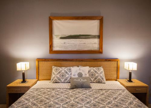 1 dormitorio con 1 cama con 2 lámparas y 1 foto en Hotel Plaza Marbella Granada en Granada