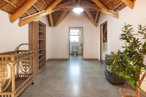 an indoor hallway with wooden ceilings and plants at Bayview Bliss at Springerbaai Luxury Eco Villa with Ocean Views & Beach Access in Mossel Bay